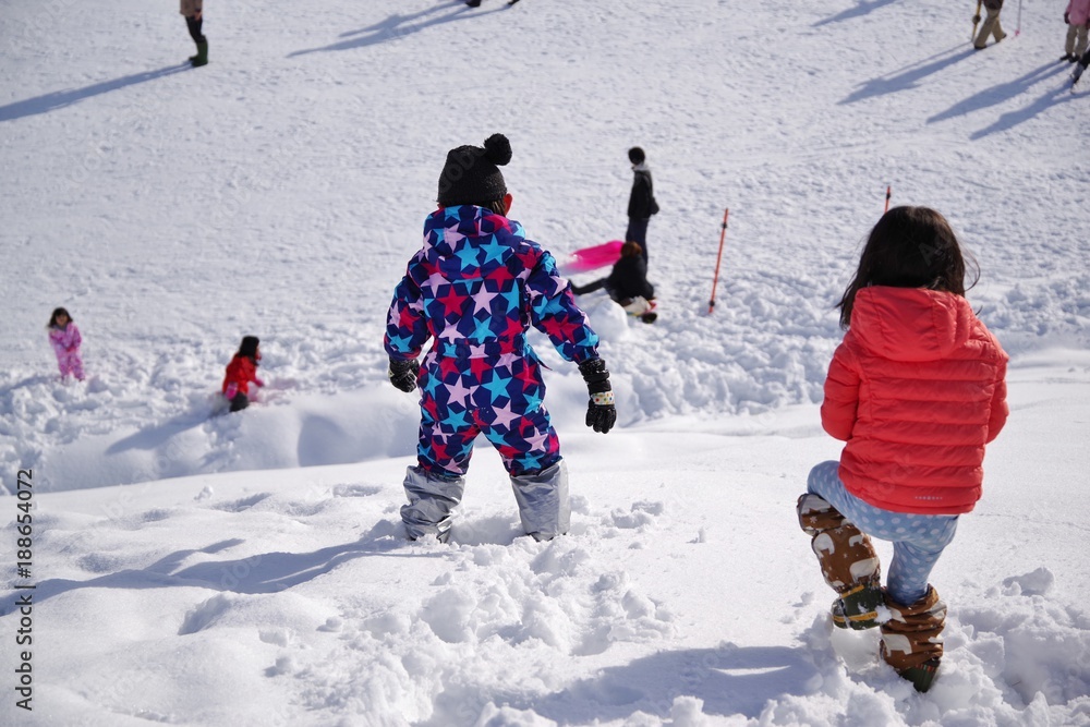 スキー場で雪遊びをする子供たち