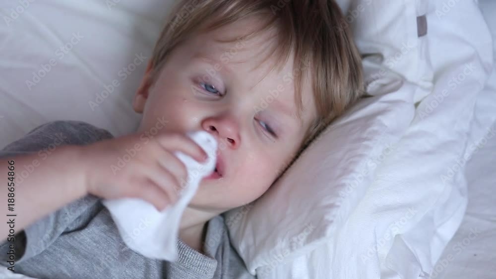 Sick two years old child boy on the bed at home - coughing and flaunt Sick two years old child boy on the bed at home - coughing and flaunt