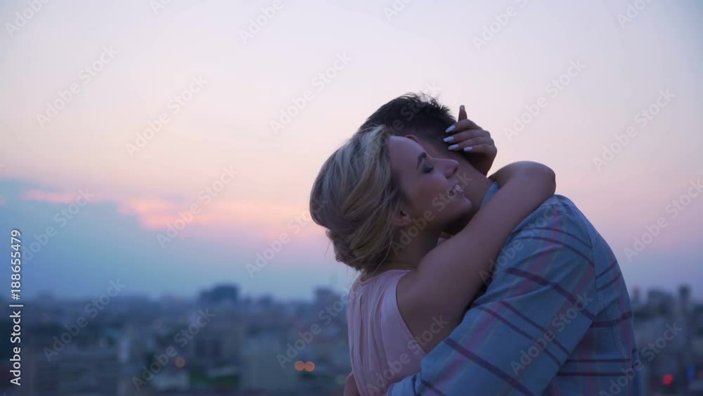 Lady tenderly and gently hugging her boyfriend dissolving in warmth of his body Lady tenderly and gently hugging her boyfriend dissolving in warmth of his body