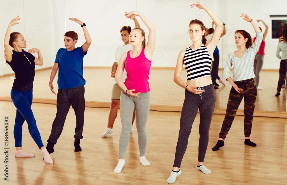 Positive teenagers practicing at the ballet classe