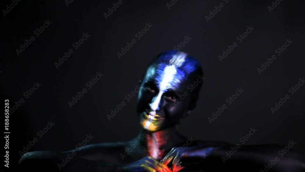 Body art portrait of a dark-skinned glowing girl with color make-up Body art portrait of a dark-skinned glowing girl with color make-up
