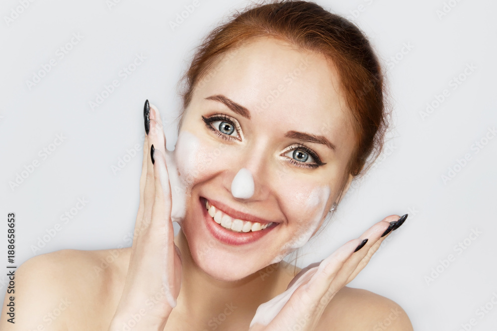 Red-haired girl in foam for washing isolated on gray. Red-haired girl in foam for washing isolated on gray.