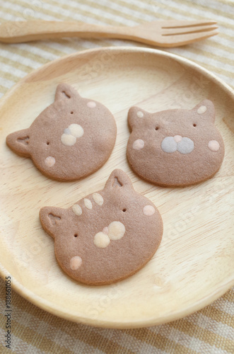 Three Pieces of Homemade Chocolate Cookies Cat Face  in Wooden Plate and Folk  
