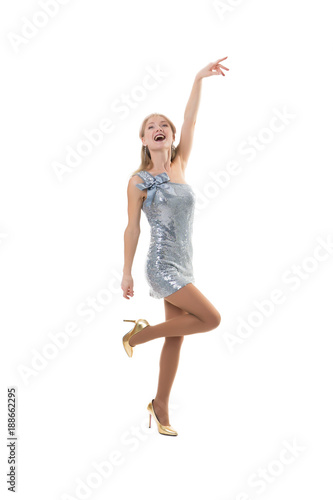 sexy girl dancing in the studio on a white background in a shiny dress - isolated