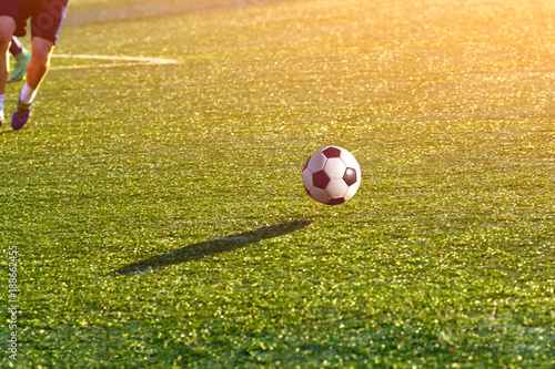 Closeup of a soccer ball in motion on a green football field. photo