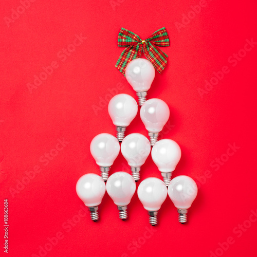 The christmas tree from lantern lamps laying on red background with copy space.