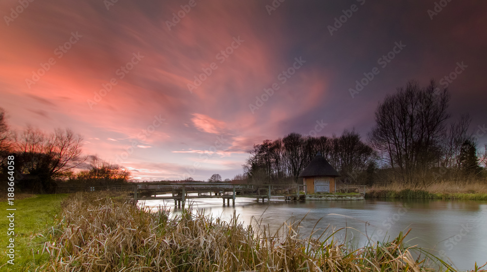 Sunset and red sky - Eel Traps and House on River Test near Longstock, Hampshire UK