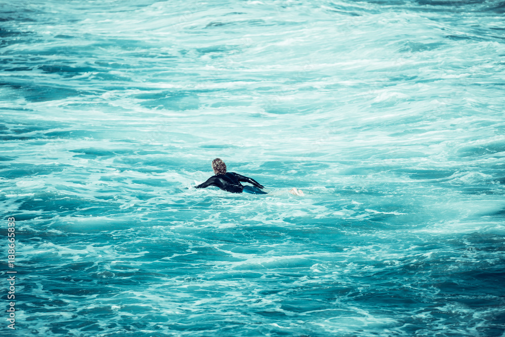 Fototapeta premium Surfing the waves of Indonesia beach