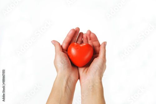 young girl holds a symbolic red heart in the palms. isolated.