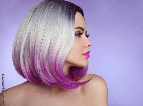 Colorful dyed Ombre hair extensions. Fashion haircut. Beauty Model Girl blonde with short bob purple hairstyle isolated on purple background. Closeup woman portrait.