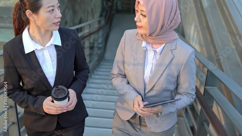 Asia and Muslim businesswoman walking up to stairway