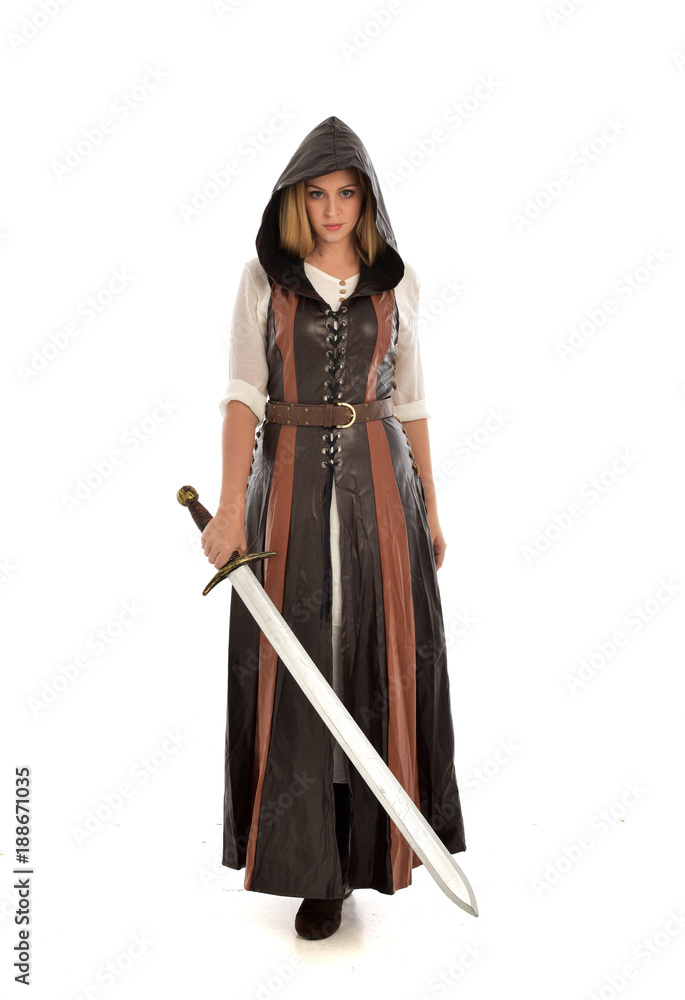 full length portrait of girl wearing brown fantasy costume, holding a sword. standing pose on white studio background. full length portrait of girl wearing brown fantasy costume, holding a sword. standing pose on white studio background.