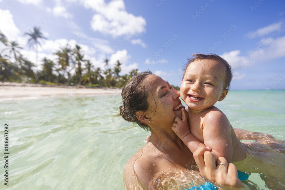 A mother with her son are swimming and playing in a sea
