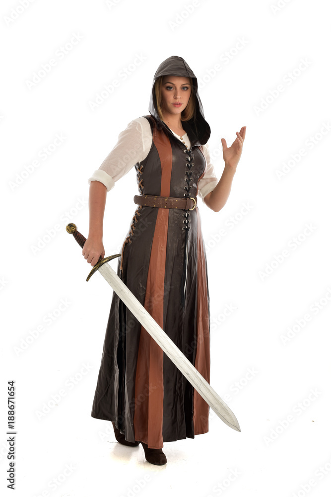 full length portrait of girl wearing brown fantasy costume, holding a sword. standing pose on white studio background. full length portrait of girl wearing brown fantasy costume, holding a sword. standing pose on white studio background.
