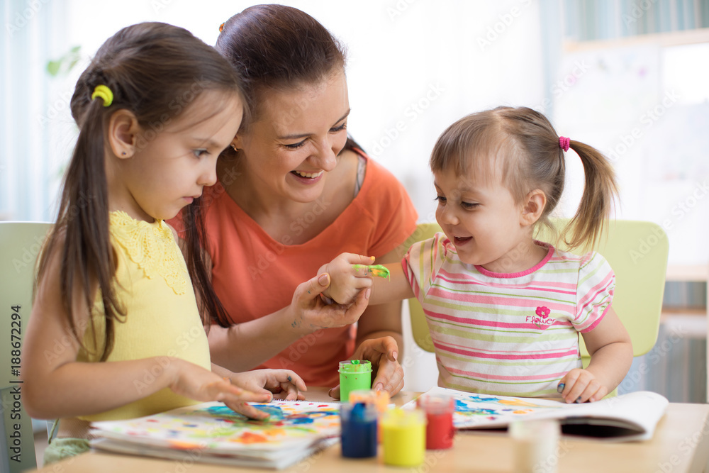 Mom and children draws with colored paints. Games with child affect early kids development. Mom and children draws with colored paints. Games with child affect early kids development.