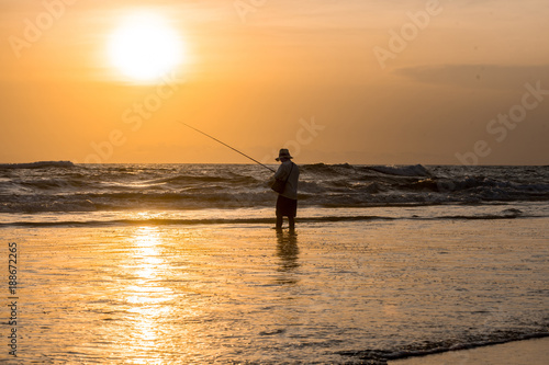 Man fishing in the evening at beach