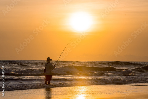 Man fishing in the evening at beach