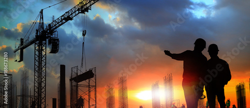 Obraz na płótnie two engineer on working site , engineer and tower cranes at construction site and city background w salonie
