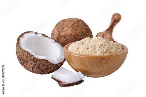 coconut flour in wooden bowl with a scoop isolated on white