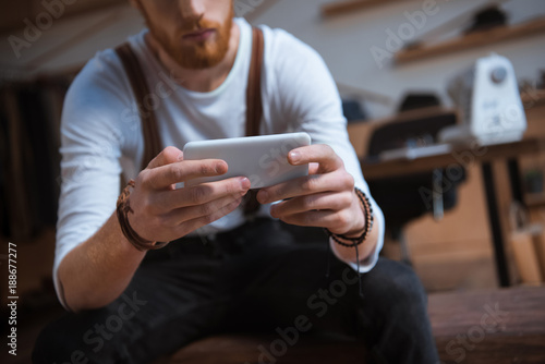 close-up view of stylish young man using smartphone