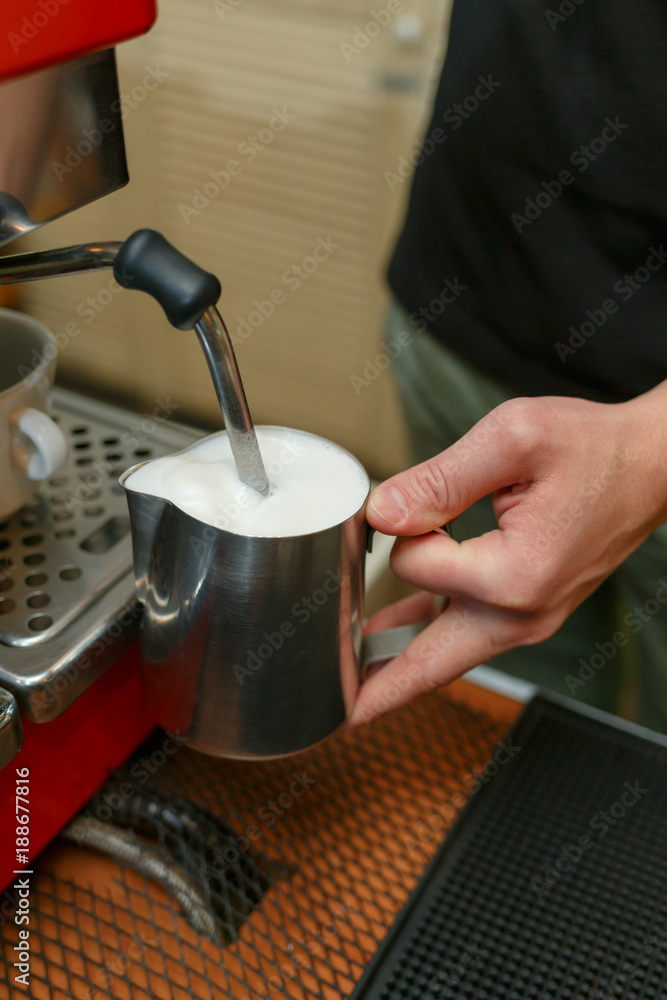 Barista makes coffees in bar. Latte preparation in coffee machine. Hands bartender cooking coffee, preparation milk for latte coffee.
