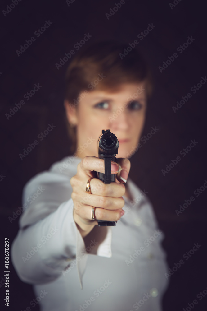 Woman with short hair aims a pistol. Woman with short hair aims a pistol.