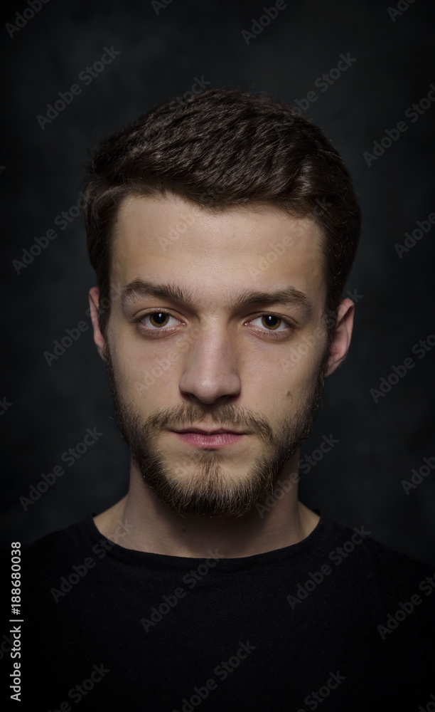 Portrait of a young man with a beard on a dark background. Portrait of a young man with a beard on a dark background.