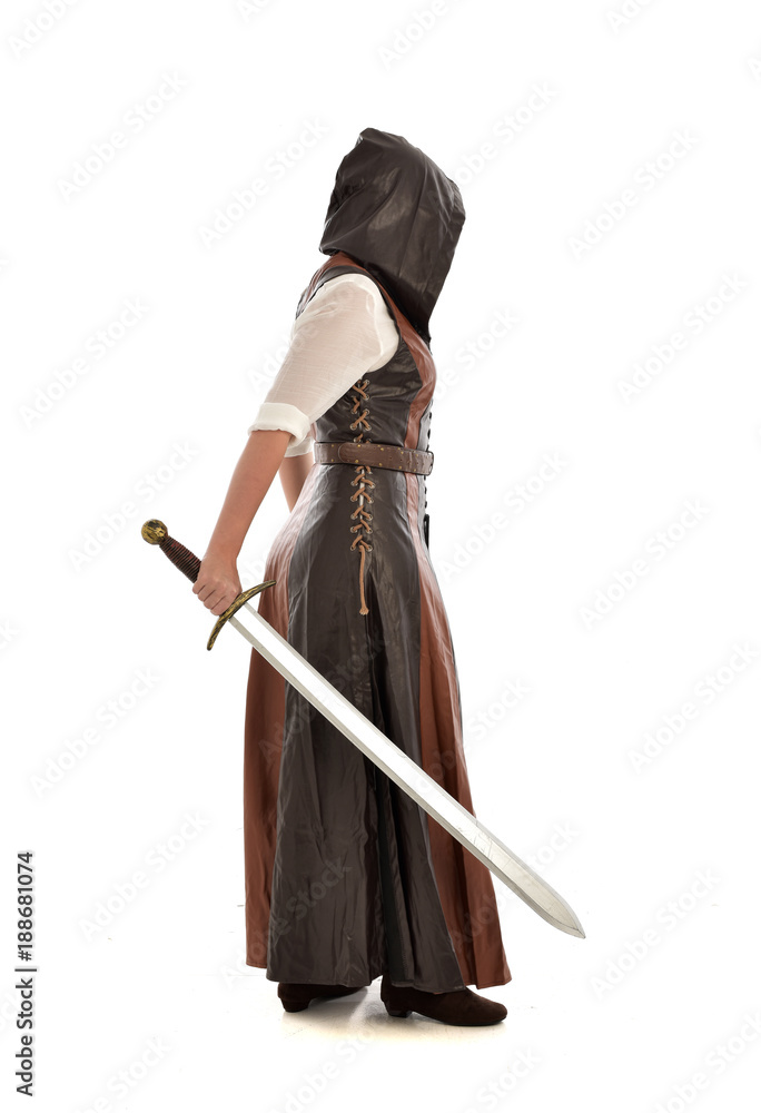 full length portrait of girl wearing brown fantasy costume, holding a sword. standing pose on white studio background. full length portrait of girl wearing brown fantasy costume, holding a sword. standing pose on white studio background.