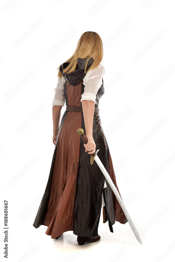 full length portrait of girl wearing brown fantasy costume, holding a sword. standing pose on white studio background. full length portrait of girl wearing brown fantasy costume, holding a sword. standing pose on white studio background.