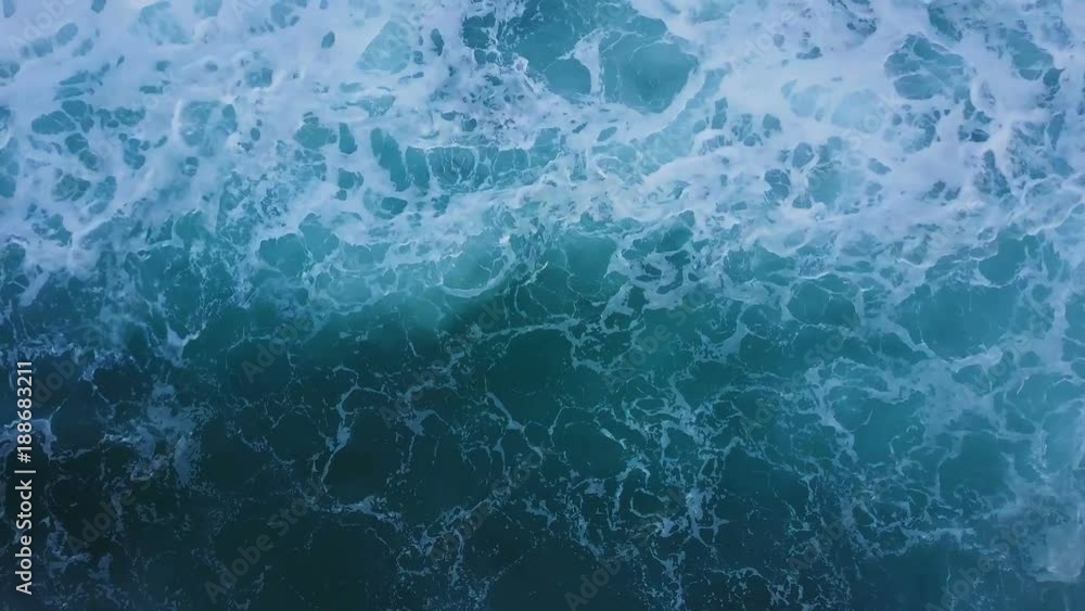Top view of ocean blue waves crashing coastline cliff drone footage Top view of ocean blue waves crashing coastline cliff drone footage