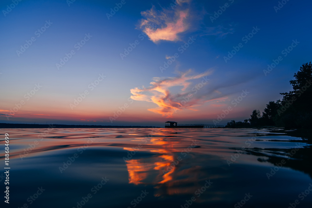 red blue sunset with beautiful reflection in water waves of sea