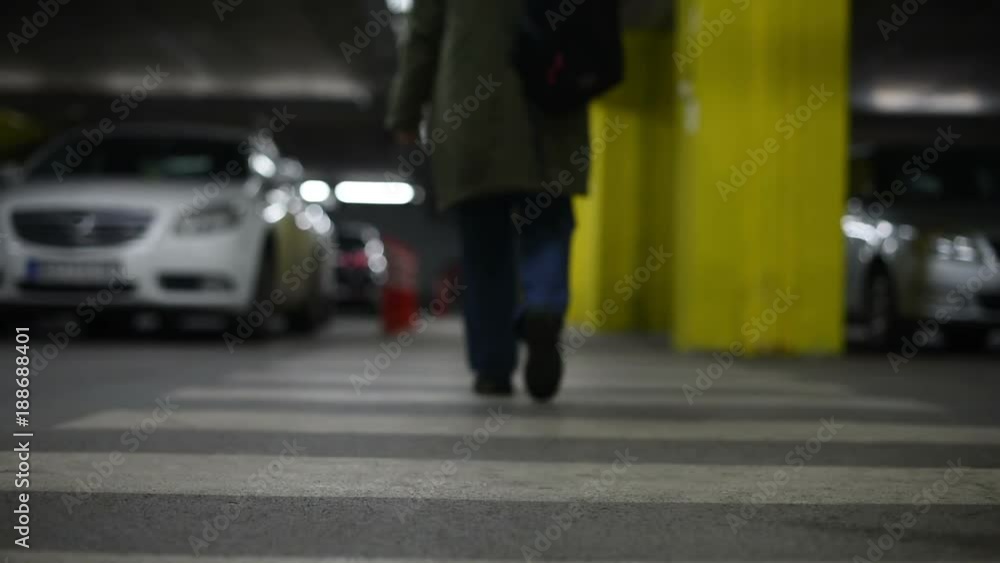 Pregnant caucasian woman walking on pedestrian zebra crossing in underground public garage Pregnant caucasian woman walking on pedestrian zebra crossing in underground public garage