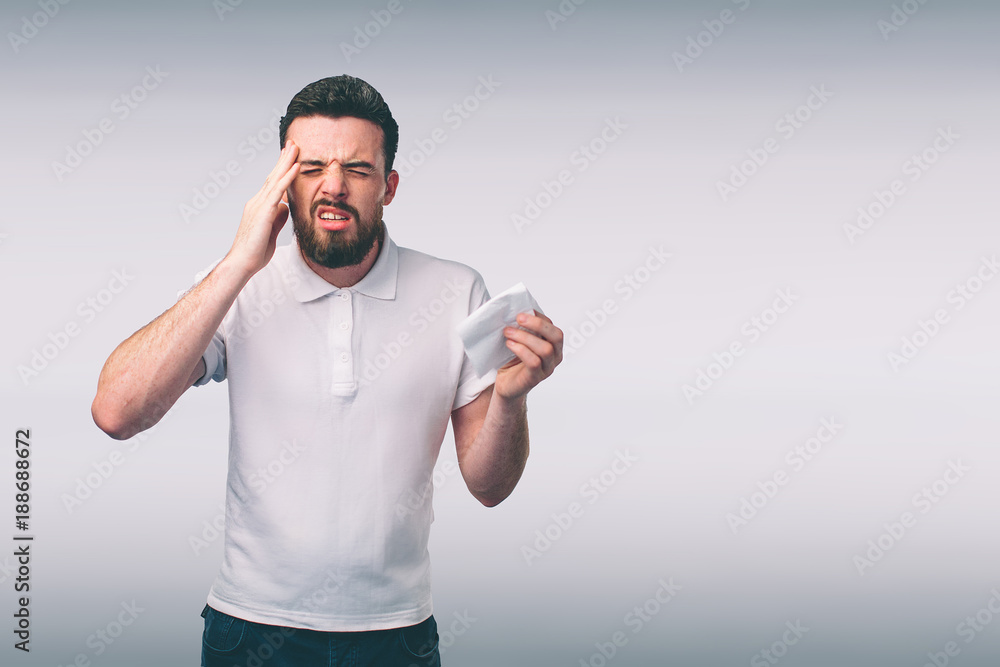 studio picture from a young man with handkerchief. Sick guy isolated has runny nose. man makes a cure for the common cold.Nerd is wearing glasses studio picture from a young man with handkerchief. Sick guy isolated has runny nose. man makes a cure for the common cold.Nerd is wearing glasses
