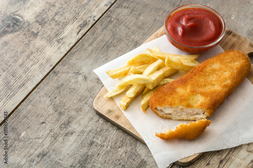 Traditional British fish and chips on wooden table.