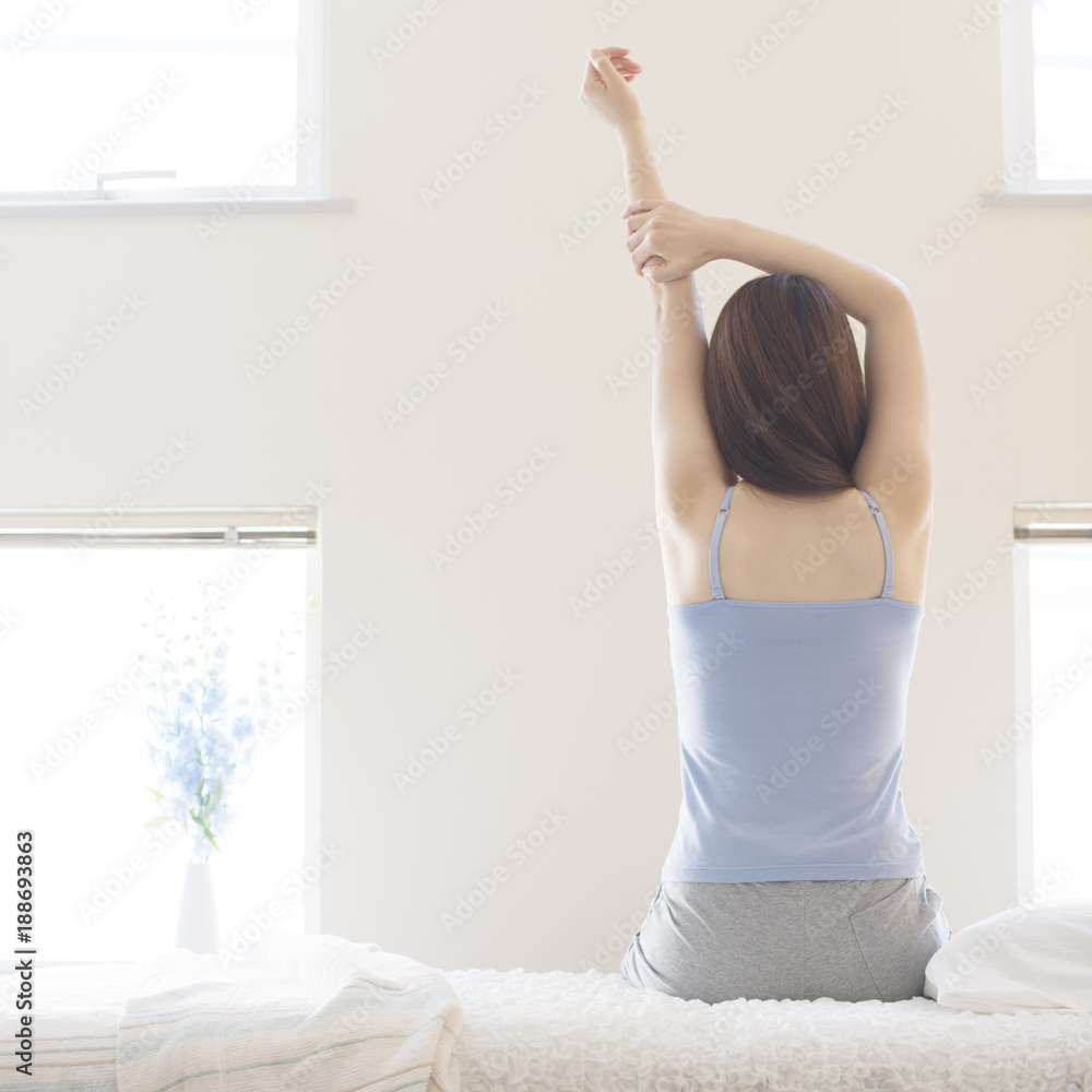 部屋で伸びをする女性の後姿 Stock Photo Adobe Stock
