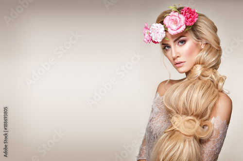 Beautiful woman portrait with long blonde hair and flowers on head. Tender bride.