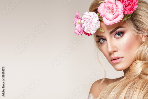 Beautiful woman portrait with long blonde hair and flowers on head. Tender bride.