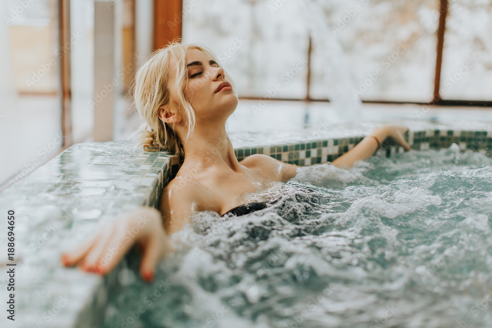 Young woman relaxing in the whirlpool bathtub - obrazy, fototapety, plakaty 