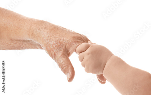 Hands of elderly woman and baby on white background