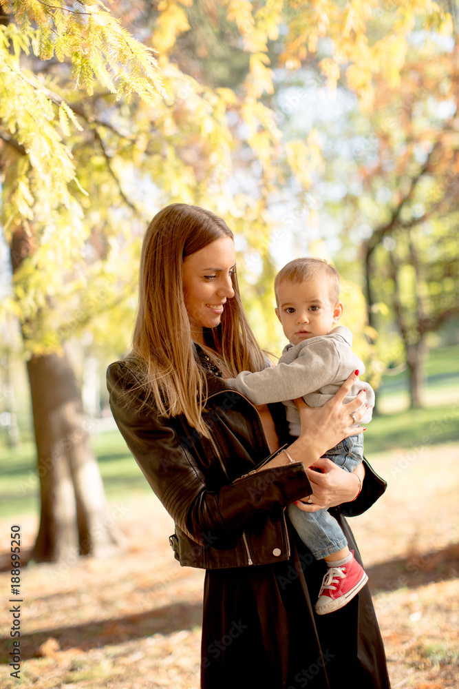 Young mother and baby boy in autumn park Young mother and baby boy in autumn park