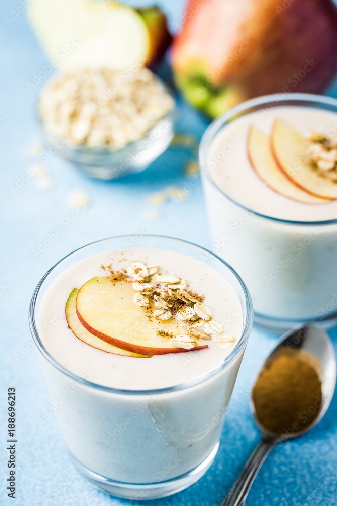 Healthy apple crisp oat smoothie in glasses on light blue background. Selective focus, space for text. Healthy apple crisp oat smoothie in glasses on light blue background. Selective focus, space for text.