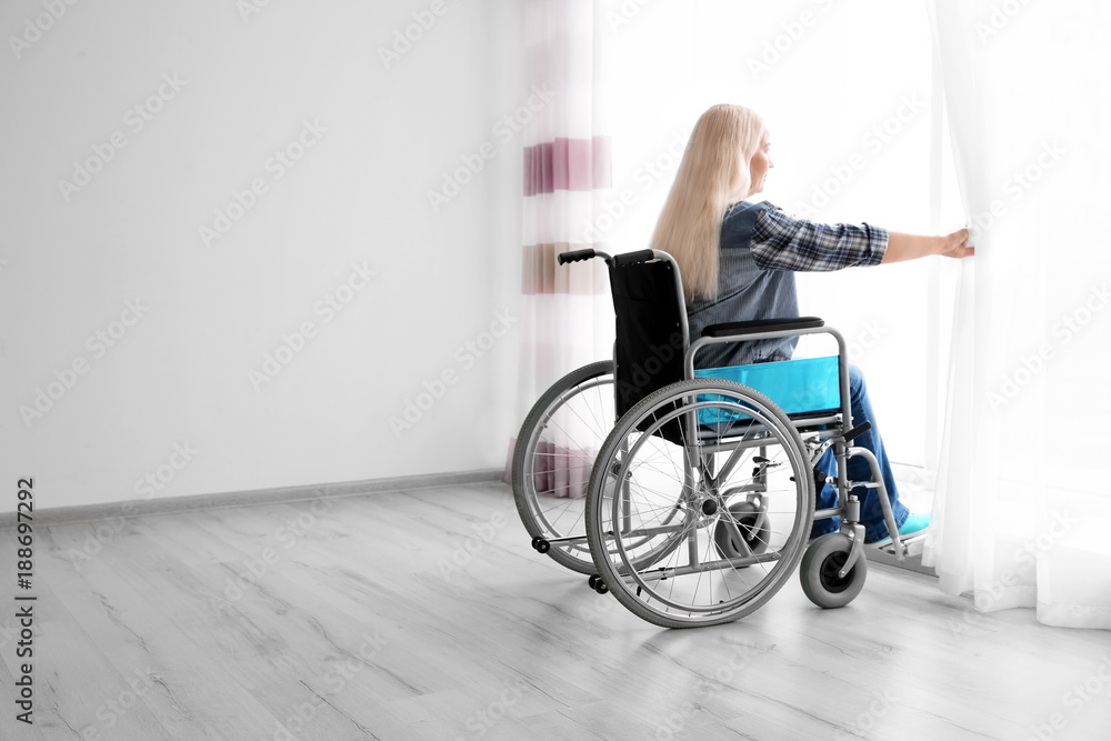 Obraz premium Mature woman in wheelchair indoors