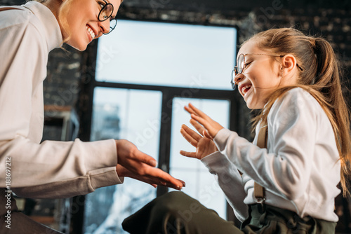 happy young mother and daughter playing pattycake photo