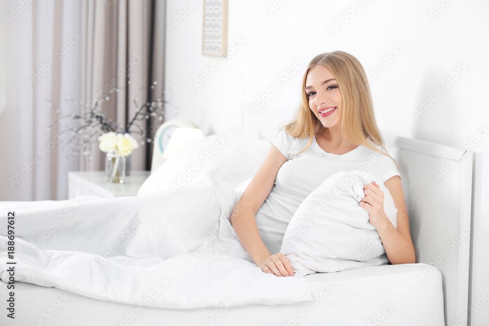 Young beautiful smiling woman in bed at home Young beautiful smiling woman in bed at home