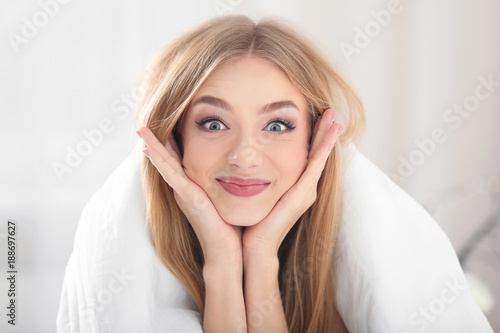 Young beautiful smiling woman with blanket at home