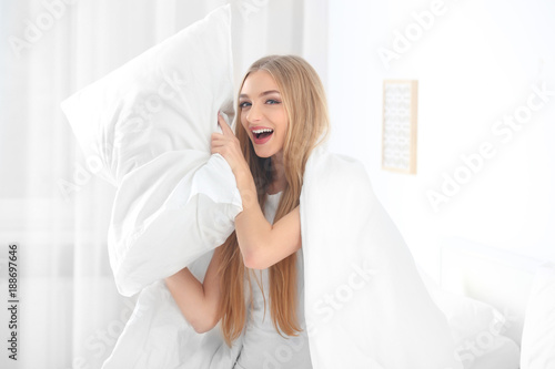 Young beautiful smiling woman with pillow at home