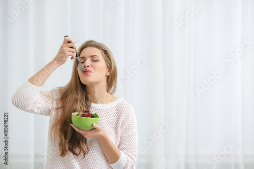 Young beautiful woman eatin...
