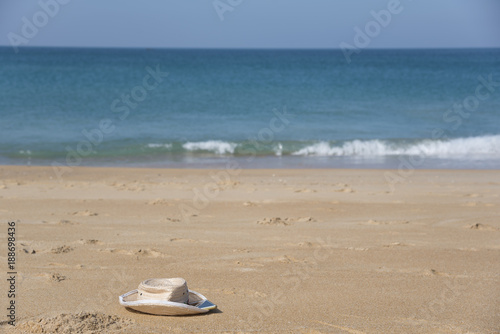 Fototapeta Naklejka Na Ścianę i Meble -  A hat and a smartphone on beautiful beach