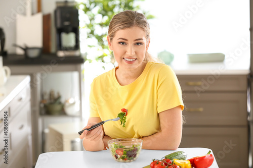 Young beautiful woman eatin...