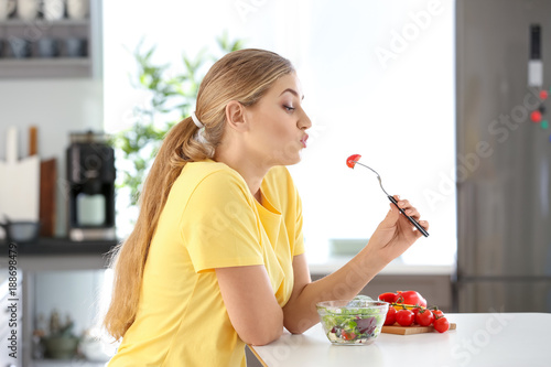 Young beautiful woman eatin...
